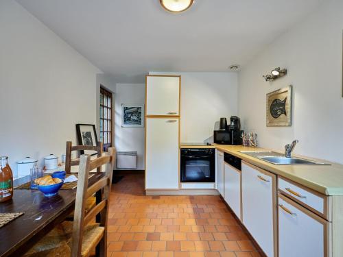 La cuisine est équipée d'une table, d'un évier et d'un réfrigérateur. dans l'établissement Holiday Home La Voisinière no-1 by Interhome, à Savigny