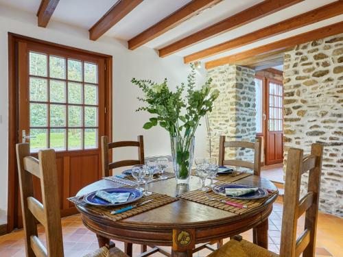 a dining room with a wooden table with a vase of flowers at Holiday Home La Voisinière no-1 - SVY400 by Interhome in Savigny