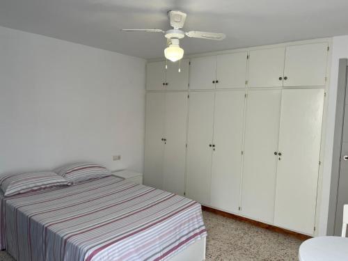 a bedroom with a bed and white cabinets at Apartamento in Almería