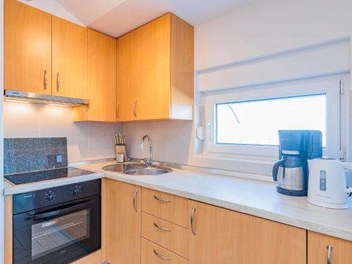 a kitchen with wooden cabinets and a sink and a window at Apartment Mlasina-6 by Interhome in Nin