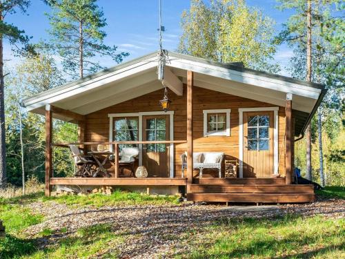 a cabin in the woods with a porch at Holiday Home Niemenkärki by Interhome in Kortteinen