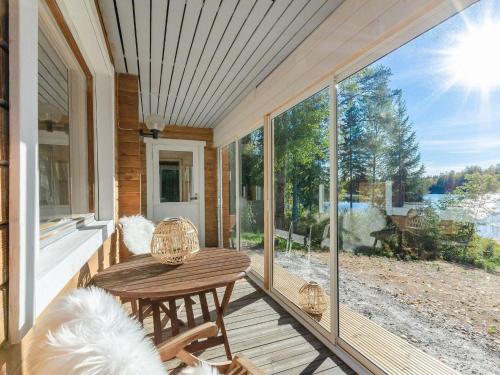 a screened porch with a table and chairs on it at Holiday Home Jussinlahti by Interhome in Kortteinen