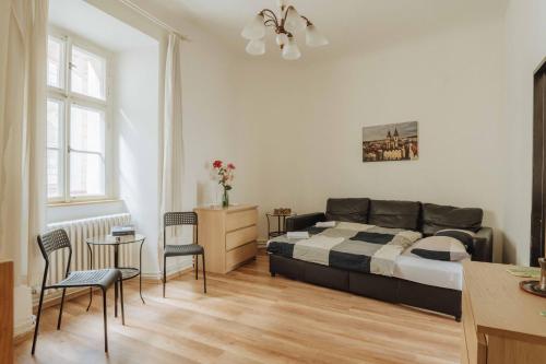 a bedroom with a bed and a table and chairs at Central 3BD Apartment Old Town Square & Astronomical Clock 100 metres in Prague