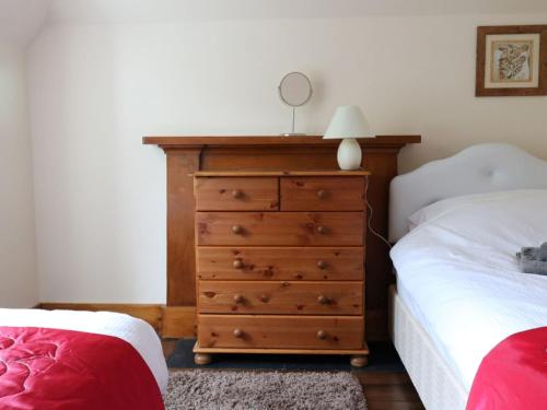 a bedroom with a dresser with a mirror on it at Holiday Home Dunan by Interhome in Dunan