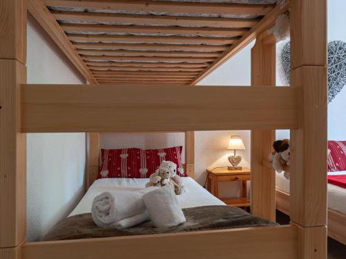 a teddy bear sitting on a bed in a bedroom at Apartment Clair Matin 20 by Interhome in Nendaz