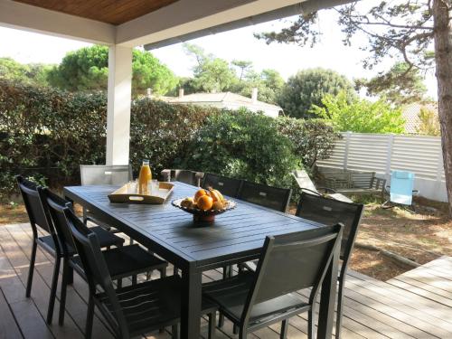 a black table with chairs and a bowl of fruit at Holiday Home Les Rougets by Interhome in La Tranche-sur-Mer
