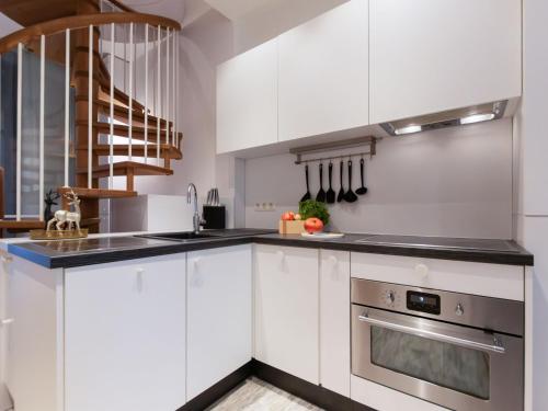 a kitchen with white cabinets and a stainless steel oven at Apartment IVA by Interhome in Bad Hofgastein