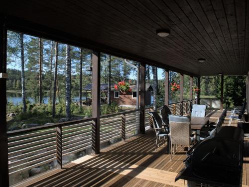 een grote afgeschermde veranda met een tafel en stoelen bij Holiday Home Lammassaari by Interhome in Kuusjärvi