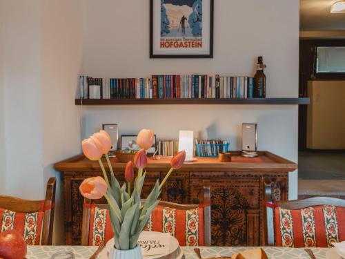a table with a vase with orange flowers on it at Apartment Sonnenappartements by Interhome in Bad Hofgastein
