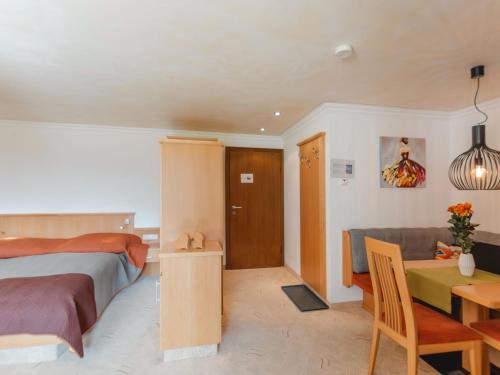 a bedroom with a bed and a table and a couch at Apartment Rose by Interhome in Bad Hofgastein