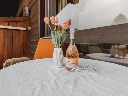 a bottle of wine sitting on a table with a vase of flowers at Apartment Anna-Katharina by Interhome in Bad Hofgastein