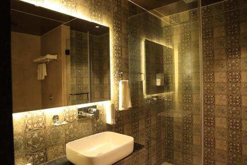 y baño con lavabo y espejo. en Krown Palace Resort en Silvassa