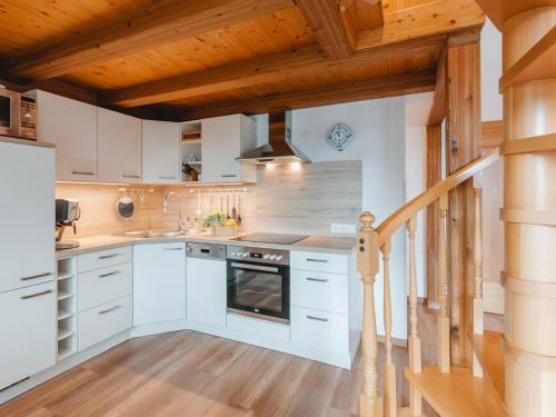 a kitchen with white cabinets and a wooden ceiling at Apartment Anna-Katharina by Interhome in Bad Hofgastein