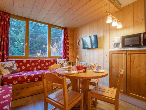 une salle à manger avec une table et un canapé dans l'établissement Apartment Boëdette 109 A by Interhome, aux Menuires