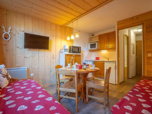 une cuisine et une salle à manger avec une table et des chaises dans l'établissement Apartment Boëdette 109 A by Interhome, aux Menuires