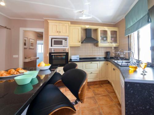 una cocina con armarios de madera y encimeras negras en Holiday Home Las Islas by Interhome, en La Venteta