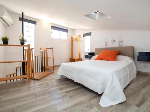 una camera con un letto bianco e un cuscino arancione di Holiday Home Las Islas by Interhome a La Venteta