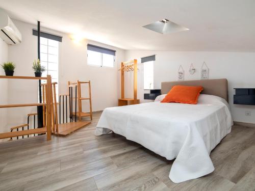 1 dormitorio con cama blanca y almohada naranja en Holiday Home Las Islas by Interhome, en La Venteta
