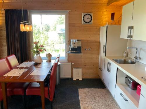 uma cozinha com uma mesa de madeira e uma cozinha com uma janela em Chalet Wilsumer Berge by Interhome em Wilsum