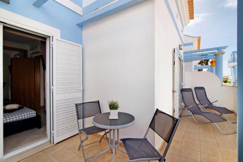 a balcony with a table and chairs in a room at Ideal Villas Residence in Vila Nova de Cacela