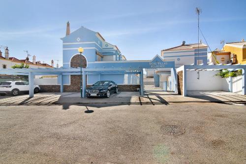 a car parked in a parking lot in front of a building at Ideal Villas Residence in Vila Nova de Cacela