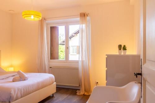 1 dormitorio con cama y ventana en ZenBNB / Chesterfield / Proche Commerce / Parking, en Annemasse