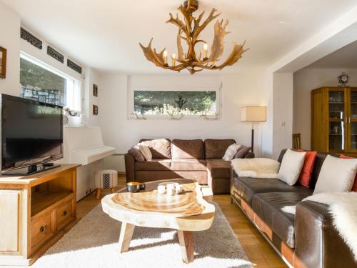 a living room with a couch and a tv at Chalet Mon Rêve by Interhome in Champex