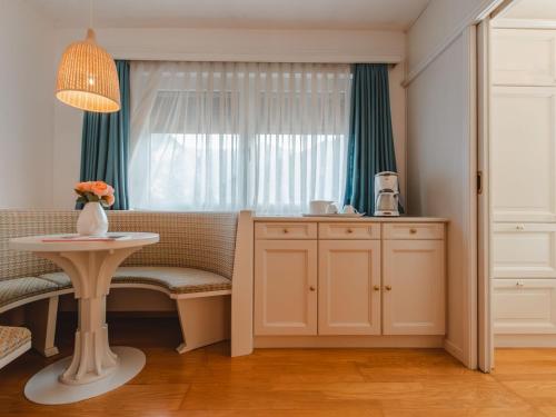 ein Wohnzimmer mit einem Tisch und einem Fenster in der Unterkunft Apartment Schbert-Franz Top 12 by Interhome in Bad Hofgastein