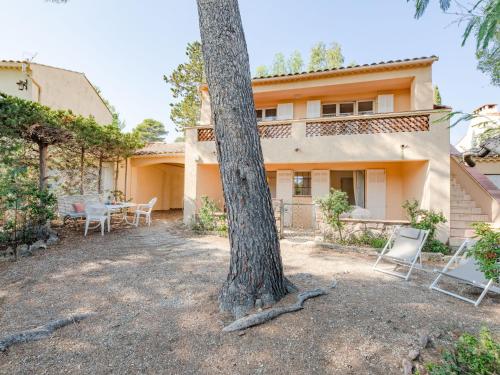 une maison avec des chaises et un arbre en face de celle-ci dans l'établissement Holiday Home Marysol by Interhome, aux Issambres
