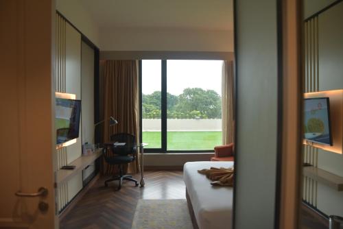 a hotel room with a bed and a desk and a window at Hotel Polo Towers Agartala in Agartala