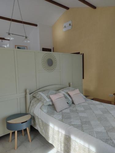 a bedroom with a bed with two pillows and a chair at Gîte l' Arbre de Vie in Les Essards