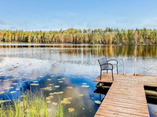 un banco sentado en un muelle sobre un lago en Holiday Home Osmola by Interhome, en Joutsa
