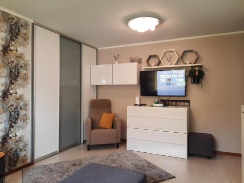 Lennuki Apartement في راكفيري: غرفة معيشة مع تلفزيون وخزانة بيضاء