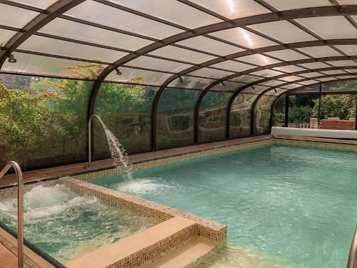 a large swimming pool with an arched roof at Bleu Minuit La Source in Wolxheim