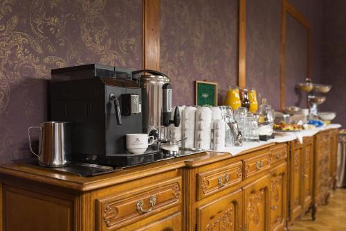 Una línea de gabinetes de madera con una cafetera encima. en Wellness & Spa hotel Villa Regenhart, en Jeseník