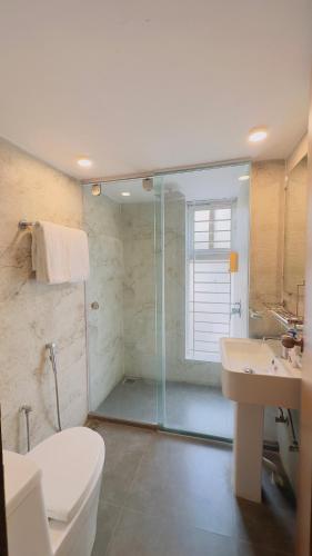 a bathroom with a shower and a toilet and a sink at Priyo Nibash Stylish Residential Hotel in Dhaka