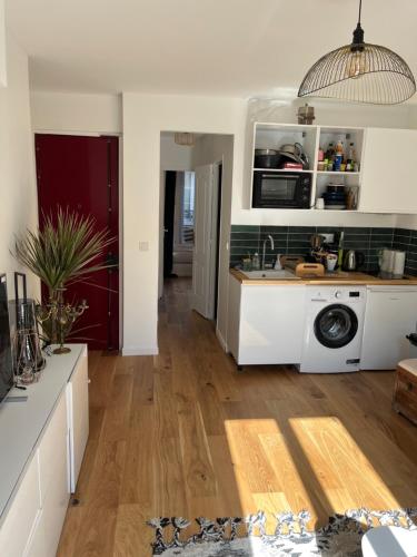 une cuisine avec un évier et une machine à laver dans l'établissement Appartement 2 pièces tout neuf Buttes Chaumont, à Paris
