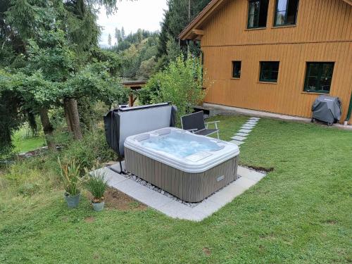 una bañera de hidromasaje en un patio junto a una casa en Holiday Home Ferienhaus Reiter by Interhome, en Rohrbach