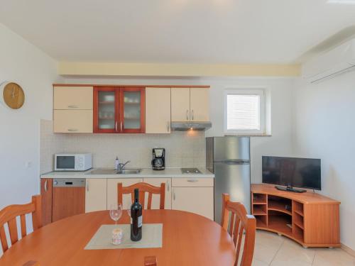a kitchen with a wooden table and a dining room at Apartment Irena-2 by Interhome in Privlaka