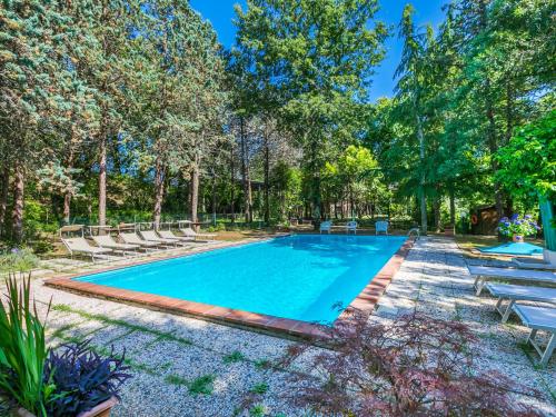 a swimming pool with lounge chairs and trees at Holiday Home Villa Alari by Interhome in Cetona