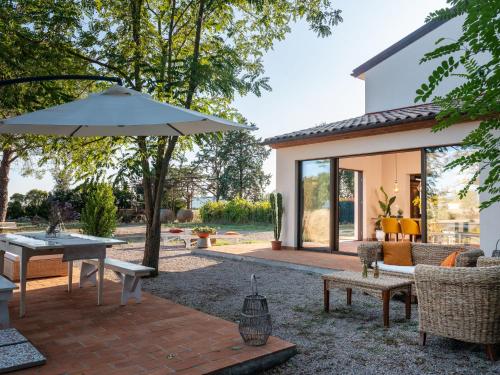 a patio with a table and an umbrella at Holiday Home Podere San Fermo by Interhome in Roccastrada