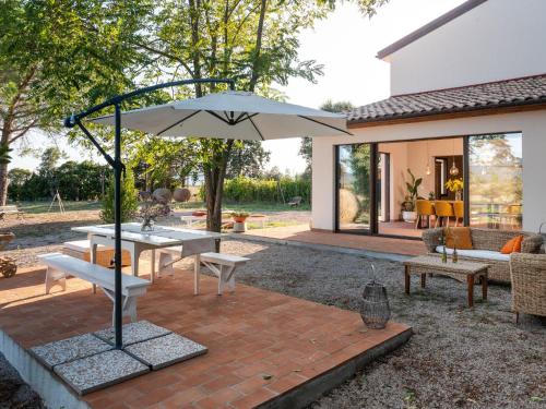 a patio with a table and an umbrella at Holiday Home Podere San Fermo by Interhome in Roccastrada