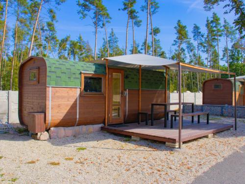 a tiny house with a table and an umbrella at Holiday Home Kemp Stříbrný rybník-7 by Interhome in Hradec Králové