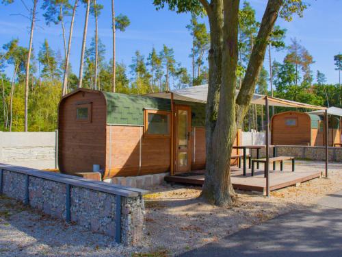 a cabin in a park with a tree at Holiday Home Kemp Stříbrný rybník-6 by Interhome in Hradec Králové