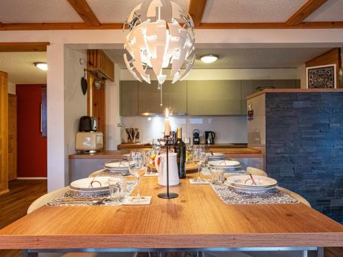 een keuken met een tafel met glazen en een kroonluchter bij Apartment Hyacinthe by Interhome in Villars-sur-Ollon