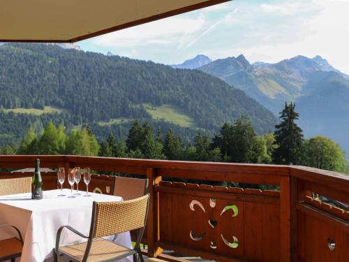 a table with wine glasses on a balcony with mountains at Apartment Les Cîmes by Interhome in Gryon