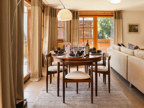 a dining room with a table and a couch at Apartment Les Cîmes by Interhome in Gryon