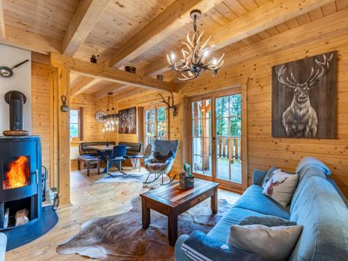 a living room with a blue couch and a fireplace at Chalet Schwabenhütte by Interhome in Sirnitz-Sonnseite