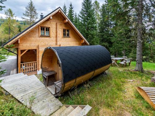 uma grande casa de madeira com um grande telhado preto em Chalet Schwabenhütte by Interhome em Sirnitz-Sonnseite