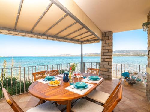 una sala da pranzo con tavolo e vista sull'oceano di Apartment Donatella by Interhome a Cannigione